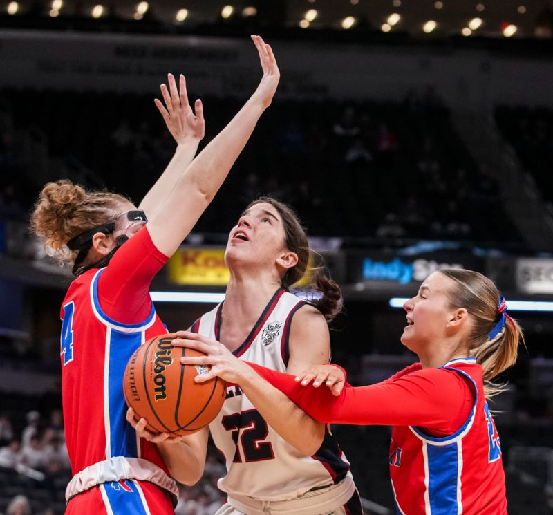Bellmont guard Ashley Bleke (22) goes up for a basket against Roncalli Royals guard Elliot Leffler (24) and Roncalli Royals guard Reagan Turk (23) on Saturday, Feb. 28, 2026, during the Class 3A IHSAA girls state basketball championship game at Gainbridge Fieldhouse in Indianapolis.