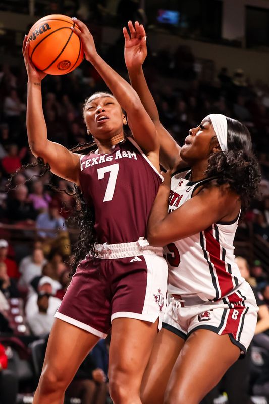 Jan 9, 2025; Columbia, South Carolina, USA; Texas A&M Aggies guard Kyndall Hunter (7) drives as South Carolina Gamecocks guard Raven Johnson (25) defends in the second half at Colonial Life Arena. Mandatory Credit: Jeff Blake-Imagn Images