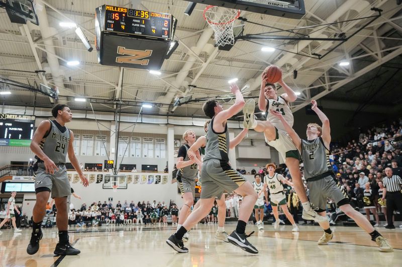 Zionsville Eagles forward Nicholas Snively (11) rebounds the ball against Noblesville Millers forward Max Flanagan (32) and Noblesville Millers guard Adam Fine (2) on Tuesday, March 3, 2026, during an IHSAA boys basketball sectionals matchup at Noblesville High School in Noblesville, Ind.