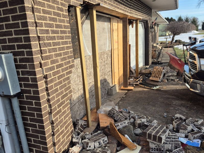 Wood patches and props David and Brenda Depoy's garage where a vehicle crashed through it on Feb. 26, with Brenda standing just feet away.