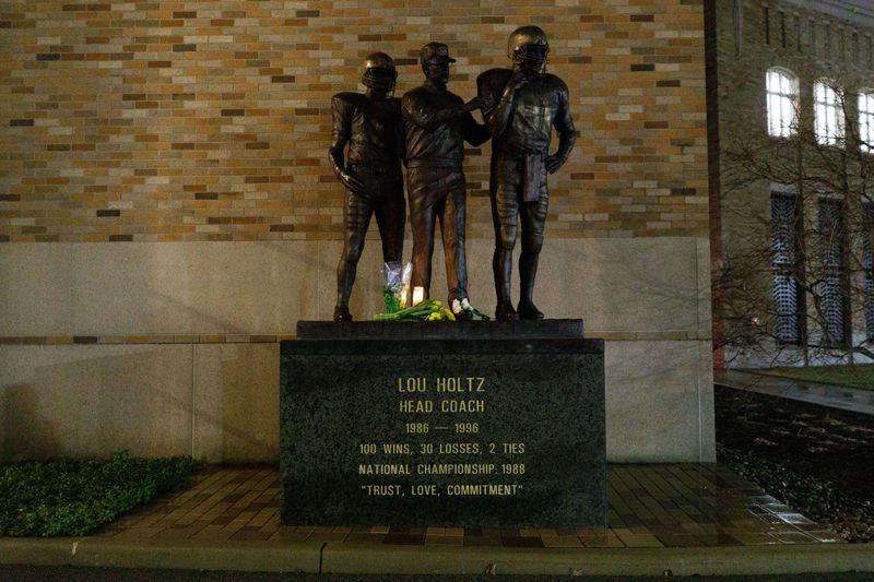 Flowers are placed on the statue of Lou Holtz outside of Notre Dame Stadium on Wednesday, March 4, 2026, in South Bend. Holtz, who died earlier in the day, was the head coach of Notre Dame football from 1986-1996, leading the team to a national championship in 1988.
