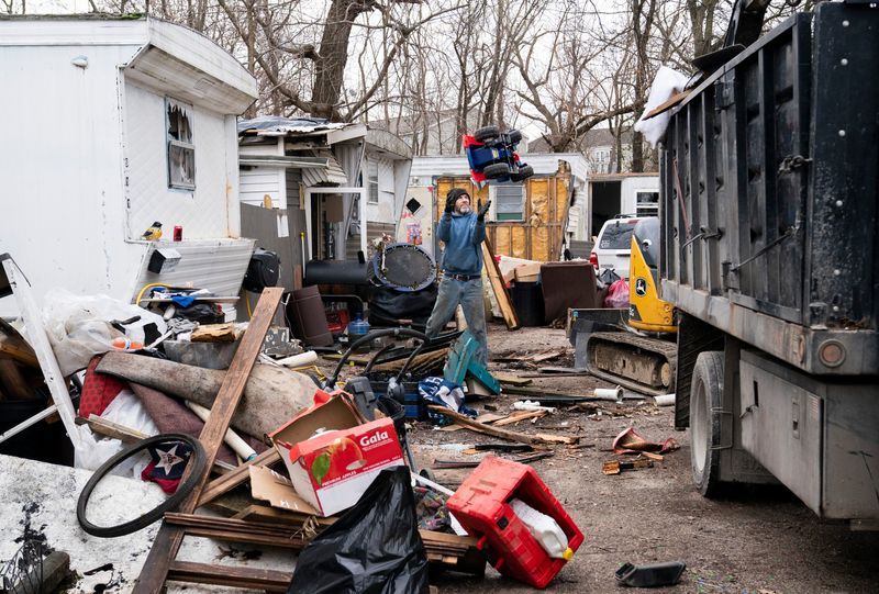 Volunteers clean up trash around a mobile home park off Oak Hill Road in Evansville, Ind., Monday morning, March 9, 2026. Residents of the park have dealt with trash dumping, remnants of fire-destroyed trailers and a negligent owner.