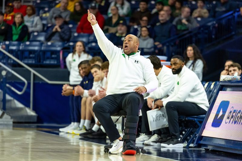 Feb 28, 2026; South Bend, Indiana, USA; Notre Dame Fighting Irish head coach Micah Shrewsberry shouts a play from a stool with wheels, due to a leg injury, against the NC State Wolfpack during the first half at Purcell Pavilion at the Joyce Center. Mandatory Credit: Michael Caterina-Imagn Images