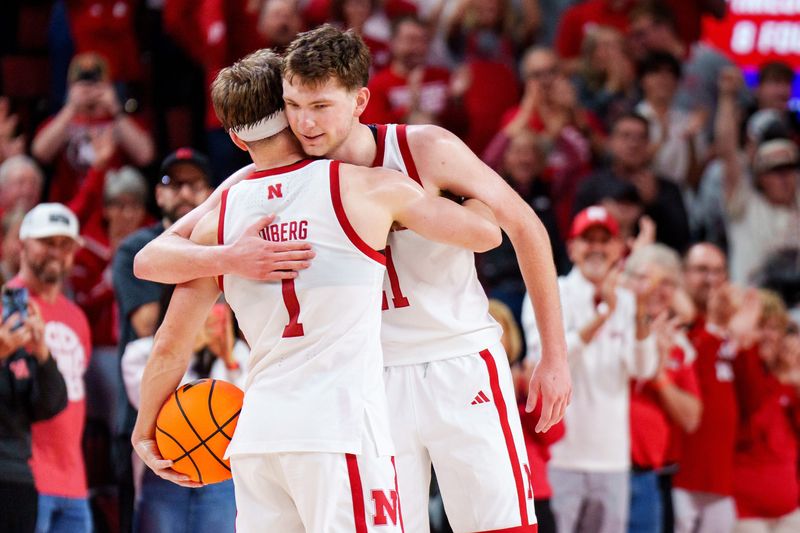 Mar 8, 2026; Lincoln, Nebraska, USA; Nebraska Cornhuskers guard Sam Hoiberg (1) and forward Pryce Sandfort (21) embrace after defeating the Iowa Hawkeyes at Pinnacle Bank Arena. Mandatory Credit: Dylan Widger-Imagn Images