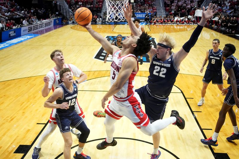 Arizona Wildcats guard Brayden Burries (5) shoots against Utah State Aggies guard Mason Falslev (12) and forward Karson Templin (22) in the first half during a second-round game of the men's 2026 NCAA Tournament at Viejas Arena.