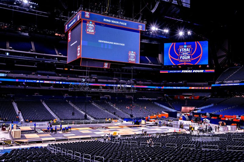 Workers install the Final Four Mens Basketball tournament floor Friday, March 27, 2026 at Lucas Oil Stadium. Seats are also put into place turning the football field into a basketball arena.