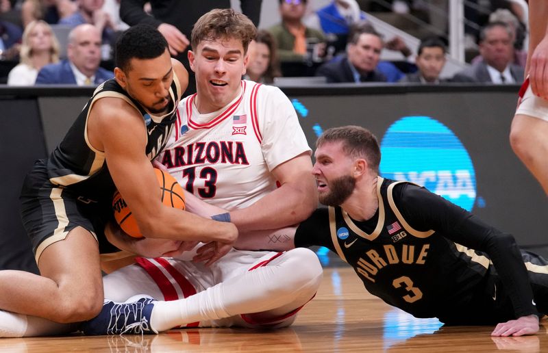 Purdue Boilermakers forward Trey Kaufman-Renn (4) and guard Braden Smith (3) battle for control of the ball with Arizona Wildcats center Motiejus Krivas (13) during a NCAA Tournament game against the Arizona Wildcats on Saturday, March 28, 2026 at SAP Center in San Jose, Calif.