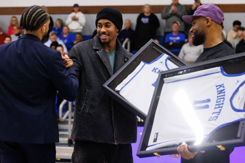 Former Marian basketball players from left to right: Devin Cannady, Jaden Ivey and Demetrius Jackson hold their jerseys with their numbers that were retired during half time of a boy's high school basketball game between Marian and Saint Joseph at Marian High School on Friday, Feb. 14, 2025, in Mishawaka.