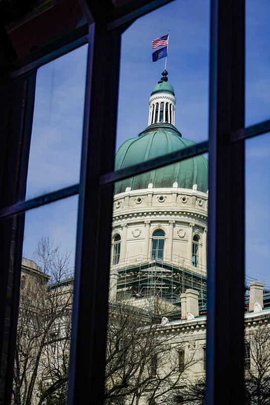 The Indiana Statehouse is reflected in the window of a building across the street on Tuesday, March 31, 2026, in Indianapolis.