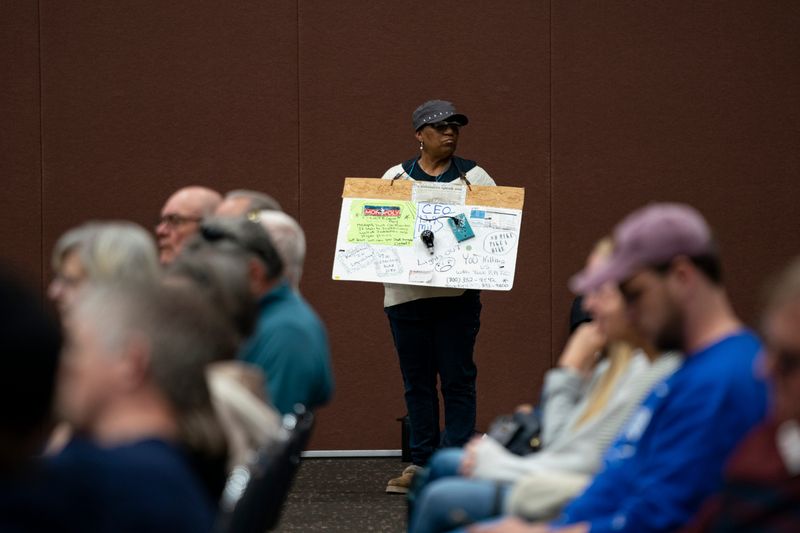 Johnnie Pegues holds a sign as the Indiana Utility Regulatory Commission holds a listening session on energy affordability at Old National Events Plaza in Evansville, Ind., Tuesday, April 7, 2026.