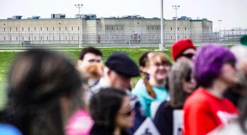 Protesters hold signs during a press conference with political and faith leaders at Miami Correctional Facility on Thursday, April 9, 2026, in Bunker Hill, Indiana.