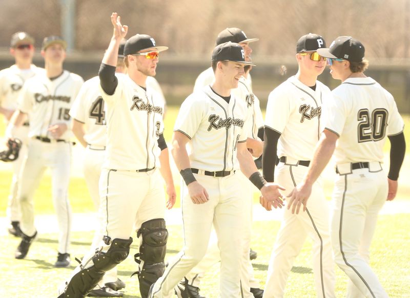 Sophomore Mason Biernacki (center) smiles as he slaps hands with senior teammate Ben Dhaemers after Penn baseball beat Carmel at Greg Dikos Field in Mishawaka April 11, 2026.