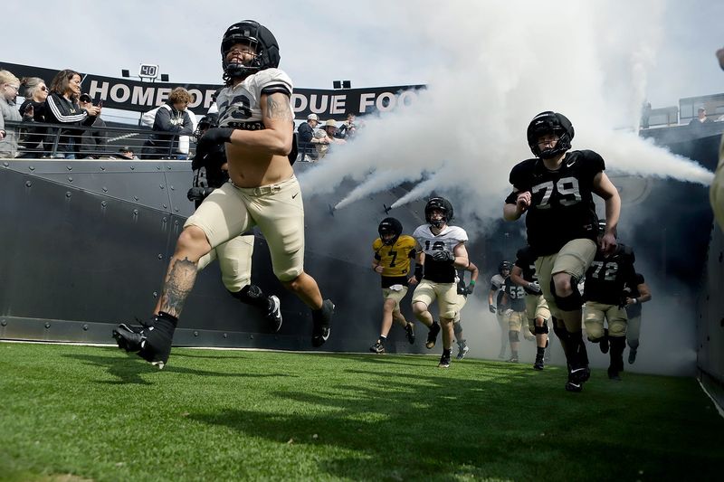 Purdue junior defensive end Trey Smith, left, and Purdue senior offensive lineman Joey Tanona run out through the tunnel at the start of the Purdue football spring showcase on Saturday, April 11, 2026, at Ross-Ade Stadium in West Lafayette, Ind.