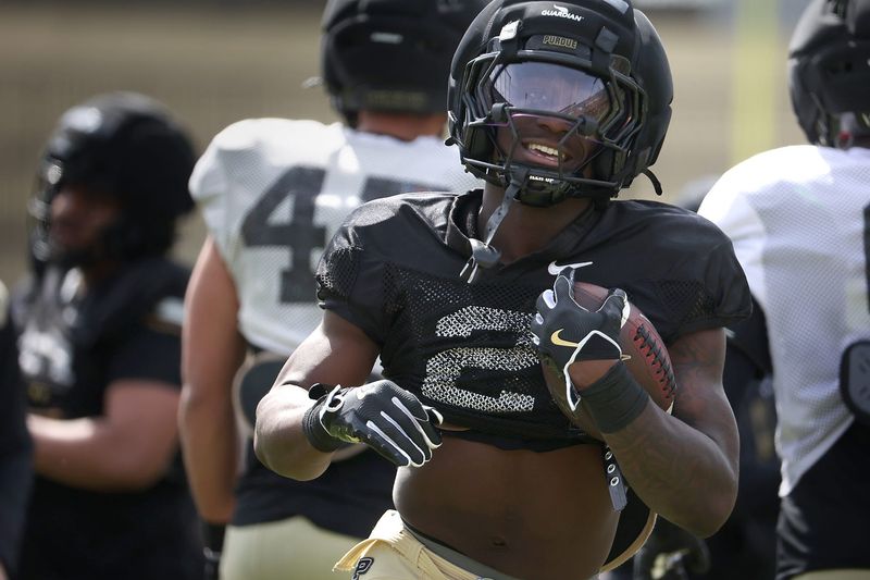 Purdue sophomore running back Fame Ijeboi runs past defenders with a football during a scrimmage at the Purdue football spring showcase on Saturday, April 11, 2026, at Ross-Ade Stadium in West Lafayette, Ind.
