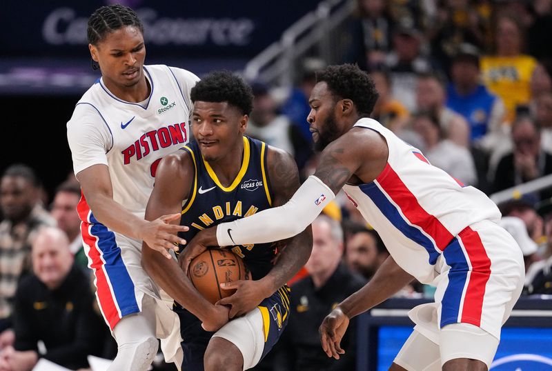 Indiana Pacers guard Kam Jones (7) wrestles for the ball against Detroit Pistons guard Ausar Thompson (9) and Detroit Pistons forward Paul Reed (7) on Sunday, April 12, 2026, during the game at Gainbridge Fieldhouse in Indianapolis.