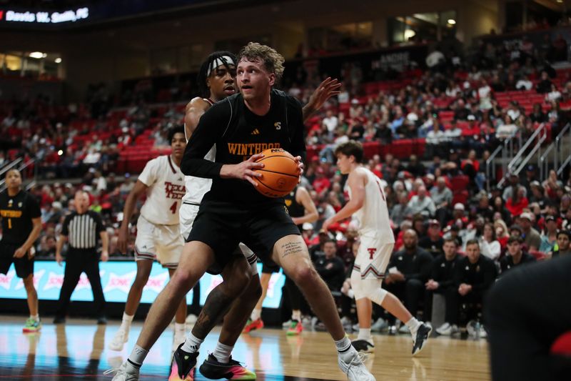 Dec 28, 2025; Lubbock, Texas, USA; Winthrop Eagles center Logan Duncomb (51) holds the ball against Texas Tech Red Raiders forward JT Toppin (15) in the second half at United Supermarkets Arena. Mandatory Credit: Michael C. Johnson-Imagn Images