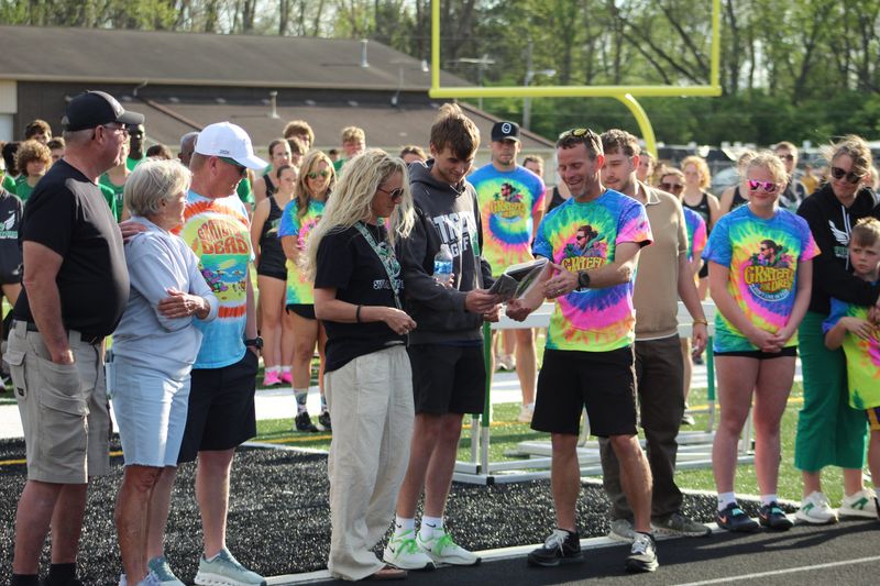 Yorktown track coach Jared Turner presents a plaque honoring pole vault coach Drew Thurston to the Thurston family during a tri meet with Delta and Jay County on Thursday, April 16. Drew Thurston passed away in August.
