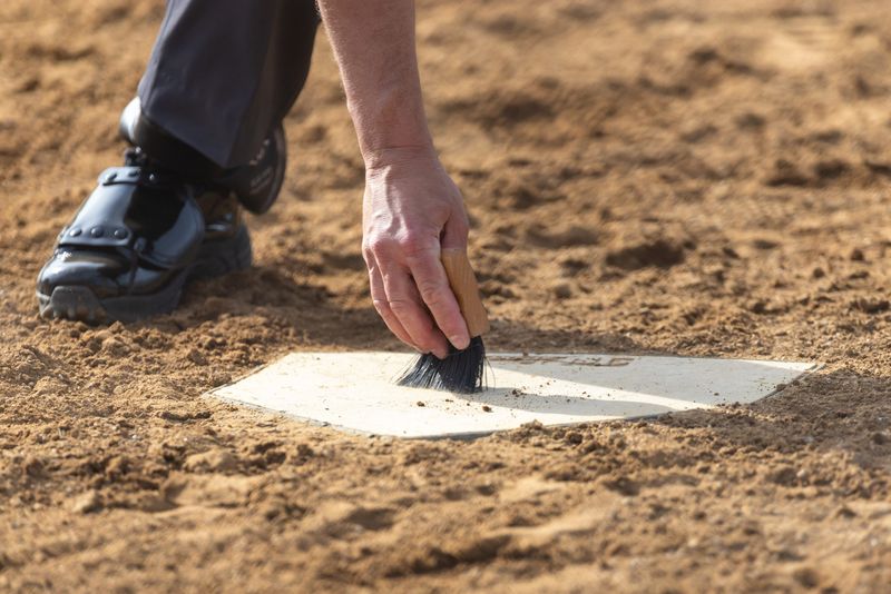 An umpire clears home plate during the Marian vs. Saint Joseph High School softball game, Friday, April 17, 2026, at the Northfield Athletic Complex.