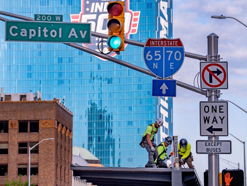 Workers work on a new bus stop on W. Washington St. at Capitol Ave., Thursday, April 23, 2026 in downtown Indianapolis. With gas prices rising, some are taking alternative modes of transportation, including IndyGo.