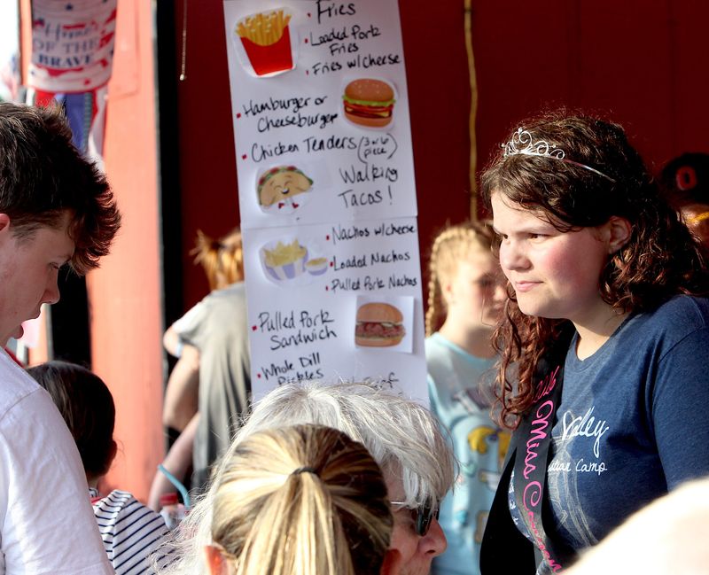 2026 Orleans Dogwood Festival Miss Congeniality Faith Dixon takes a customer's order at the Orleans Band Boosters Food tent.