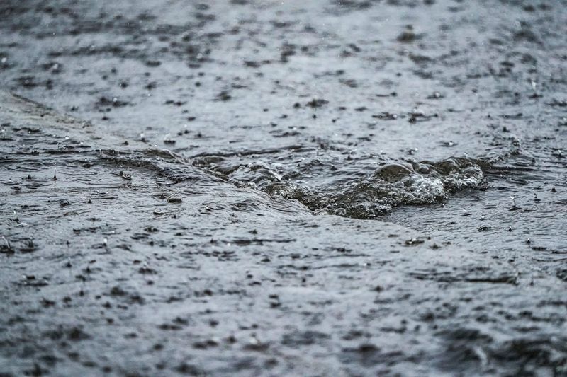 Water flows into a storm sewer after severe weather at the intersection of Meridian St. and 38th St. on Thursday, April 23, 2026, in Indianapolis.