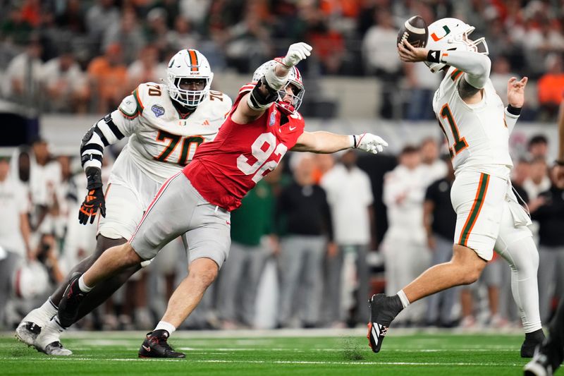 Ohio State Buckeyes defensive end Caden Curry (92) pursues Miami Hurricanes quarterback Carson Beck (11) during the Cotton Bowl at AT&T Stadium in Arlington, Texas for the College Football Playoff quarterfinal game on Dec. 31, 2025. Ohio State lost 24-14.