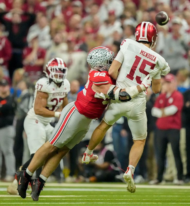 Ohio State Buckeyes defensive end Caden Curry (92) wraps up Indiana Hoosiers quarterback Fernando Mendoza (15) on Saturday, Dec. 6, 2025, during the Big Ten football championship at Lucas Oil Stadium in Indianapolis.