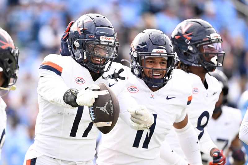 Oct 25, 2025; Chapel Hill, North Carolina, USA; Virginia Cavaliers defensive end Mitchell Melton (17) celebrates with linebacker Maddox Marcellus (11) after intercepting the ball in the third quarter at Kenan Stadium. Mandatory Credit: Bob Donnan-Imagn Images