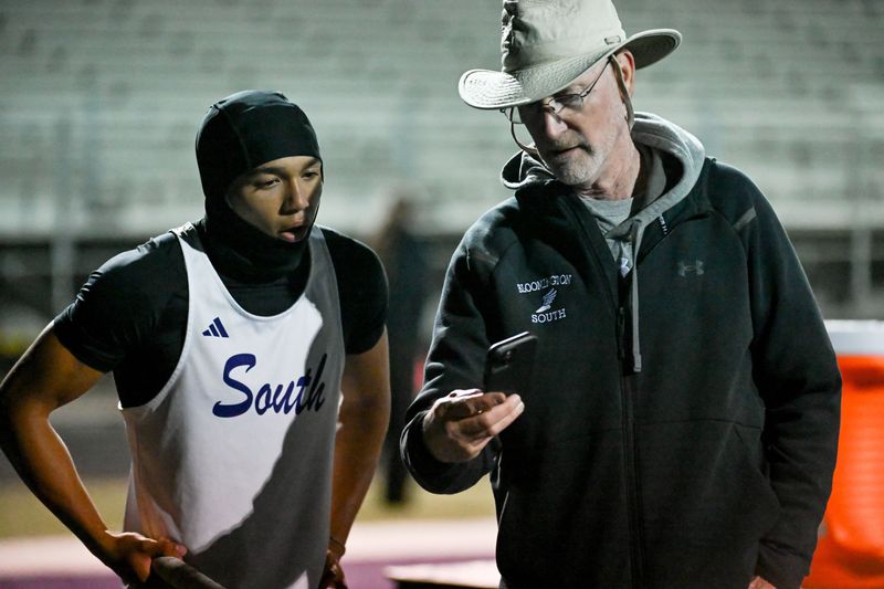 Bloomington South coach Larry Williams shares video with Arthur Banks of his last pole vault attempt during the Conference Indiana track meet at Bloomington South on Friday, May 1, 2026.