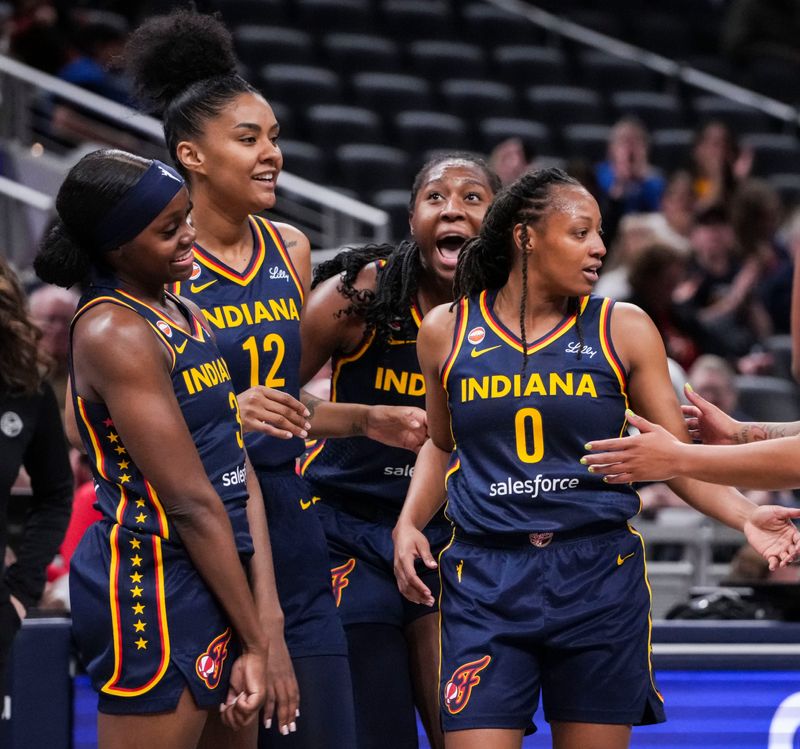 The Indiana Fever celebrate Indiana Fever guard Kelsey Mitchell (0) after a play on Saturday, May 2, 2026, during the first half of a preseason game at Gainbridge Fieldhouse in Indianapolis.
