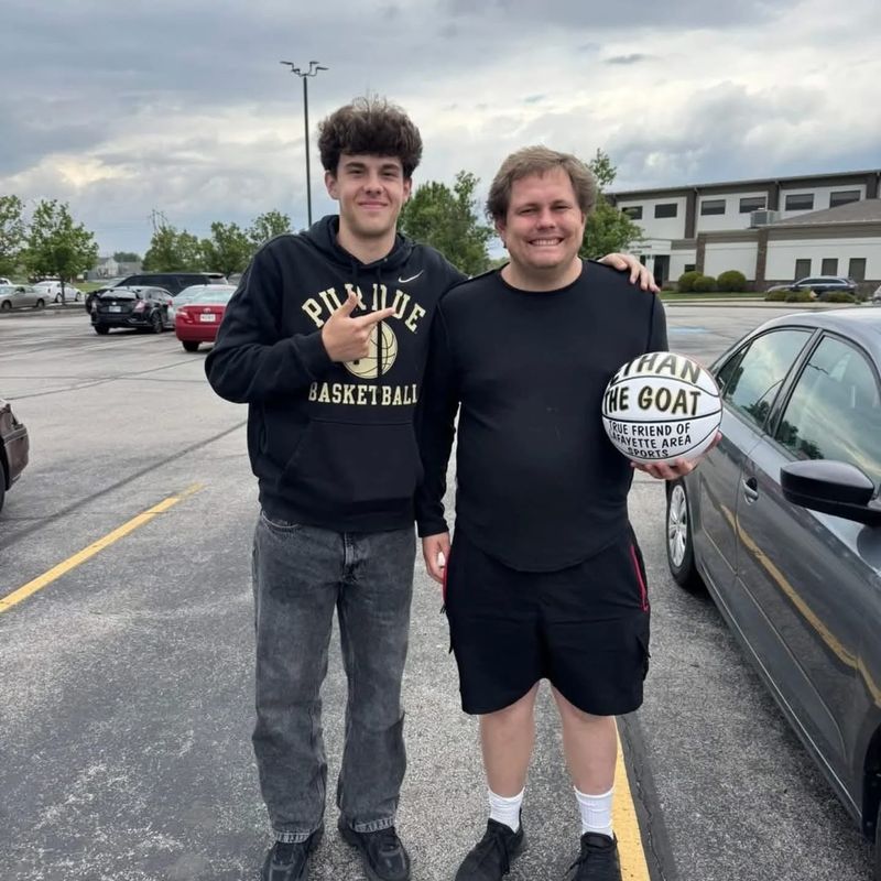 Faith Christian's Luke Barrett, left, presented a special basketball to departing Journal and Courier sportswriter Ethan Hanson before he left for his new job, a symbol of the impact Hanson had in his three years working for the newspaper.