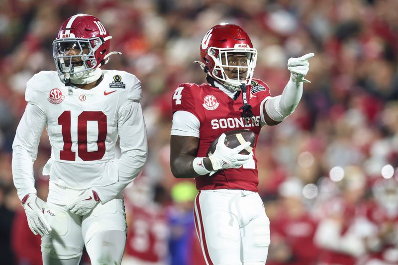 Dec 19, 2025; Norman, OK, USA; Oklahoma Sooners wide receiver Deion Burks (4) gestures in the first half against the Alabama Crimson Tide at Gaylord Family OK Memorial Stadium. Mandatory Credit: Mark J. Rebilas-Imagn Images