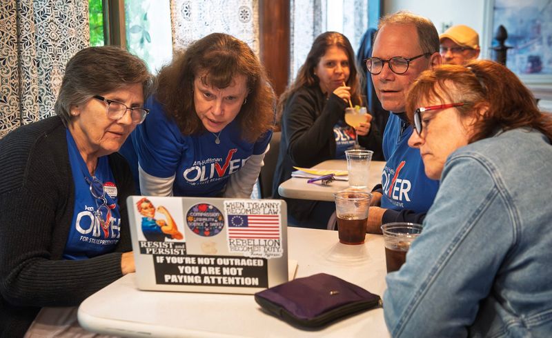 Amy Huffman Oliver, second from left, and her husband Jim, second from right, look over results with other family and supporters at the Cascades Inn on election night on Tuesday, May 5, 2026.
