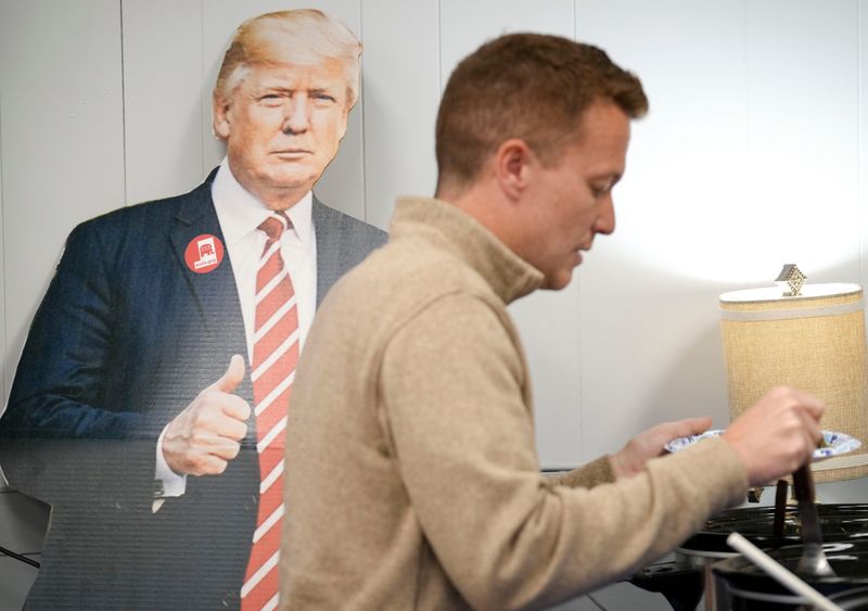 A cutout of President Donald Trump sits on the wall as Blake Fiechter, the Republican nominee for Senate District 19, gets a plate of food during an election watch party Tuesday, May 5, 2026, at the Wells County Republican Headquarters in Bluffton.