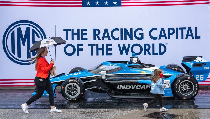 Blakely Wilson, 4, and her mother, Lindsey, walk in the rain Friday, May 8, 2026, during practice for the Sonsio Grand Prix at Indianapolis Motor Speedway.