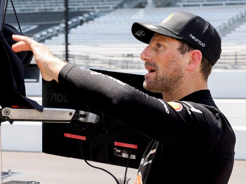 Dale Coyne Racing driver Romain Grosjean (18) talks by his pit box Tuesday, May 12, 2026, during practice for the 110th running of the Indianapolis 500 at Indianapolis Motor Speedway.