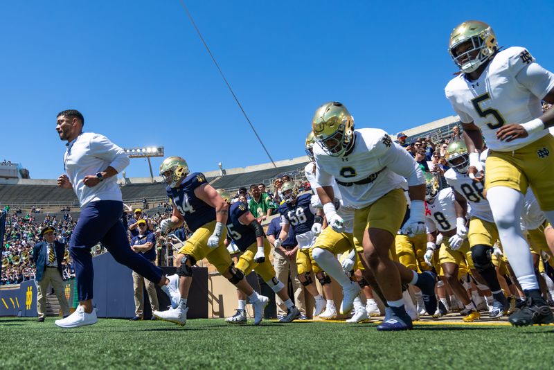 Apr 25, 2026; Notre Dame, IN, USA; Notre Dame Fighting Irish head coach Marcus Freeman runs out with the team before the Blue-Gold game at Notre Dame Stadium. Mandatory Credit: Michael Caterina-Imagn Images