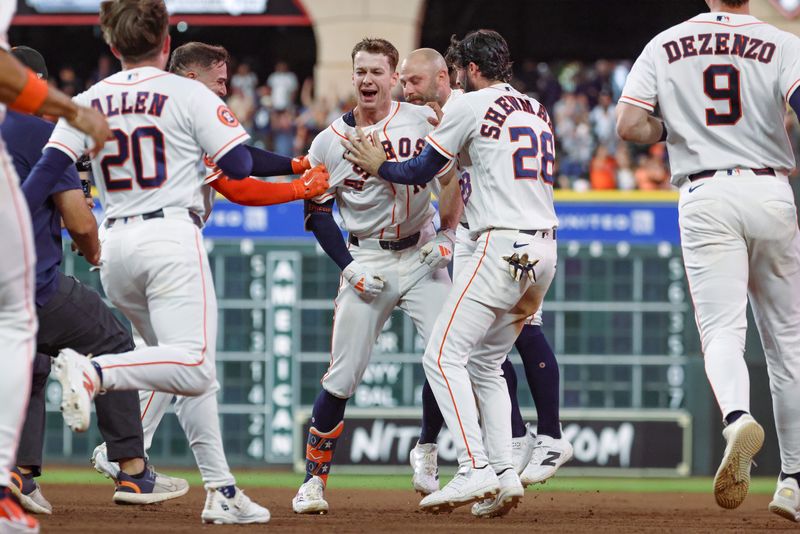 Houston Astros right fielder Zach Cole (16) is mobbed by teammates after his walk-off RBI single against the Seattle Mariners in an MLB game at Daikin Park in Houston, Texas.