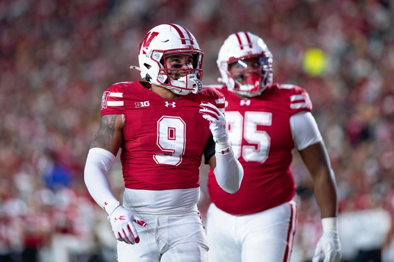 Oct 11, 2025; Madison, Wisconsin, USA; Wisconsin Badgers safety Austin Brown (9) and defensive lineman Brandon Lane Jr. (95) look at the scoreboard in the second half against the Iowa Hawkeyes at Camp Randall Stadium. Mandatory Credit: Ross Harried-Imagn Images