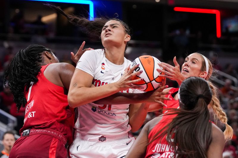 Indiana Fever forward Aliyah Boston (7), Washington Mystics center Lauren Betts (51) and Indiana Fever guard Lexie Hull (10) go for the ball Friday, May 15, 2026, during the first half of a game at Gainbridge Fieldhouse in Indianapolis. The Washington Mystics defeated the Indiana Fever in overtime, 104-102.