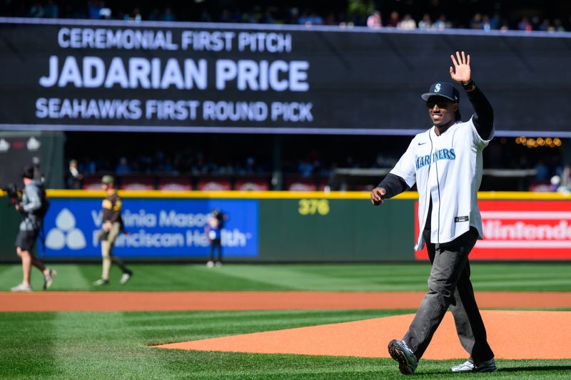 May 17, 2026; Seattle, Washington, USA; Seattle Seahawks player Jadarian Price waves to the fans after throwing out the first pitch before the game between the Seattle Mariners and the San Diego Padres at T-Mobile Park. Mandatory Credit: Steven Bisig-Imagn Images