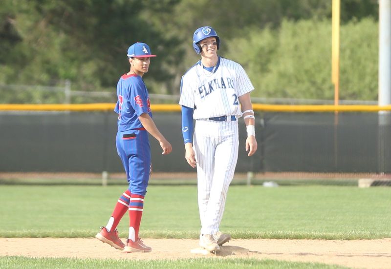 Elkhart senior Max Shreiner (right) smiles as he stands on second base next to South Bend Adams senior shortstop Kainen Smith during a baseball game Wednesday, May 20, 2026, at Elkhart High School.