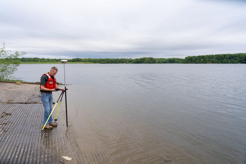 Justin Boldt, hydrologist with United States Geological Survey, uses a global positioning device that uses satellites to get a land surface elevation Thursday, May 21, 2026, at Eagle Creek Reservoir in Indianapolis.