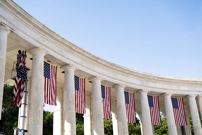 Arlington National Cemetery Facilities Maintenance employees hang U.S. flags on May 18, 2026 in the Memorial Amphitheater in preparation for the National Memorial Day Observance, Arlington National Cemetery, Arlington, Virginia.
