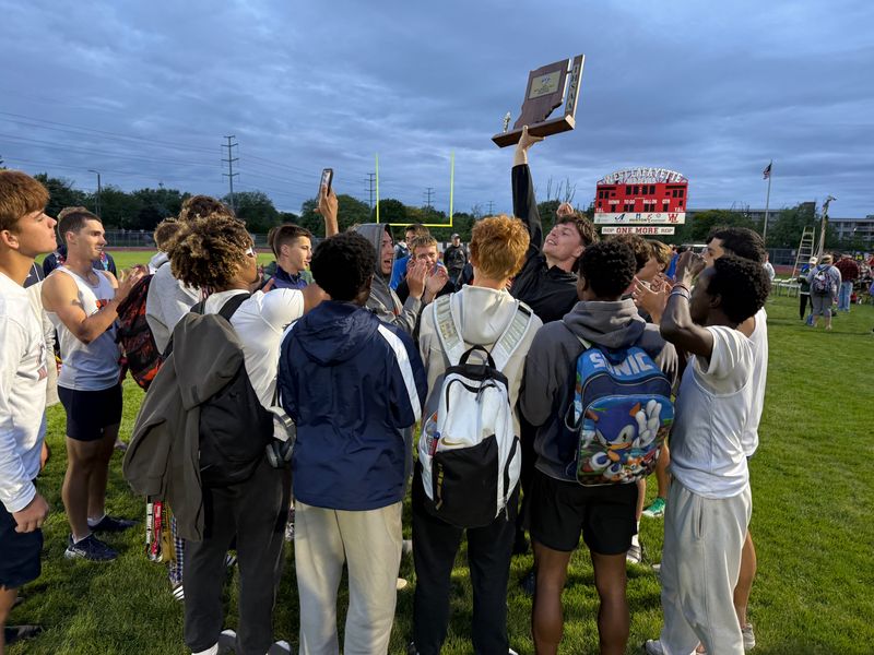 Harrison senior Jacob Schwartz raises the IHSAA boys track sectional trophy while teammates sing the school fight song at Salisbury Athletic Complex in West Lafayette on May 21, 2026.