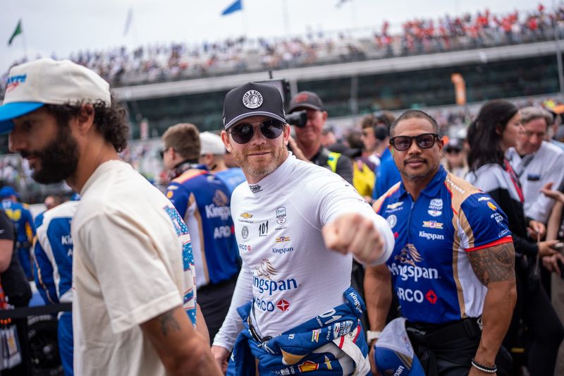 Dreyer and Reinbold Racing driver Conor Daly (23) fist bumps a fan Sunday, May 24, 2026, while standing next to Daniel Ricciardo ahead of the 110th running of the Indianapolis 500 at Indianapolis Motor Speedway.