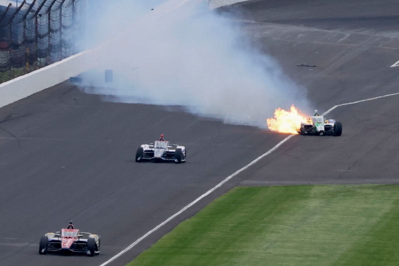 Flames shoot out of A.J. Foyt Enterprises driver Caio Collet’s (4) car after crashing in the second turn Sunday, May 24, 2026, during the 110th running of the Indianapolis 500 at Indianapolis Motor Speedway.