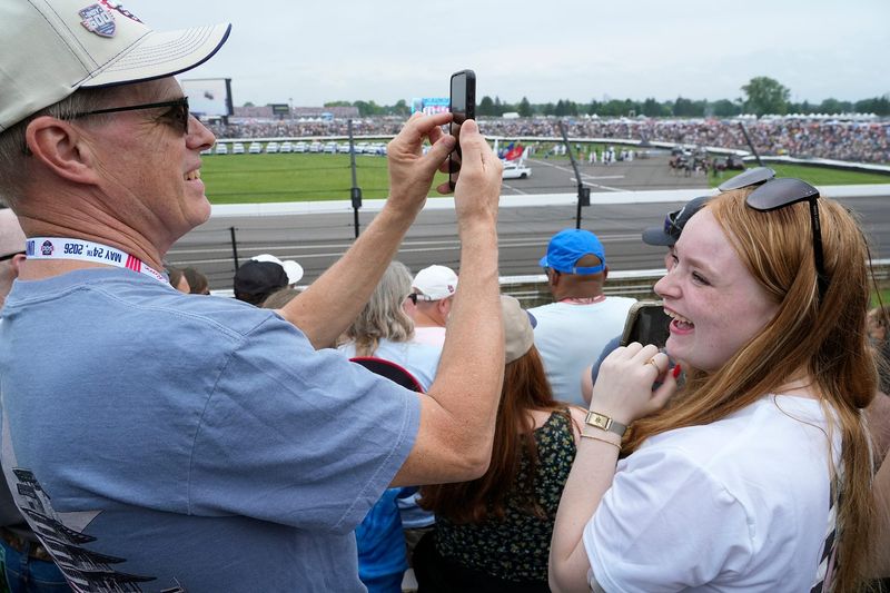 Paul Van Thomme and his daughter Jenna Van Thomme watch cars fly by Sunday, May 24, 2026, during of the 110th running of the Indianapolis 500 at Indianapolis Motor Speedway.