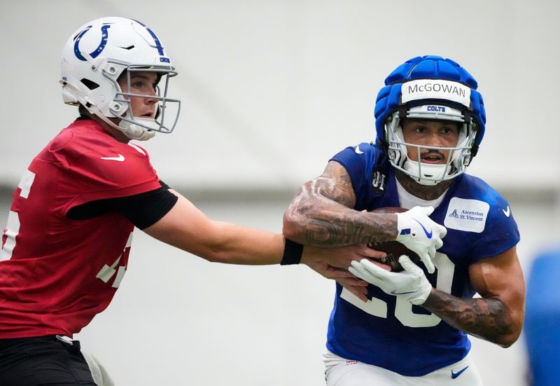 Indianapolis Colts quarterback Riley Leonard (15) hands off the ball to Indianapolis Colts running back Seth McGowan (20) on Wednesday, May 27, 2026, during practice at the Indiana Farm Bureau Football Center in Indianapolis.