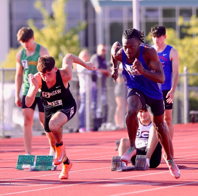 Elkhart senior Alonzo Newbern (right) participates in the 100-meter dash prelims at the IHSAA regional championships Thursday, May 28, 2026, at Warsaw High School.